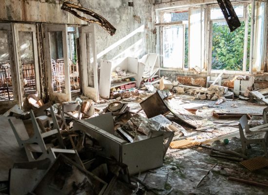 pexels-photo-1411392-1411392 A desolate room filled with decayed furniture, debris, and broken windows, illustrating urban decay.